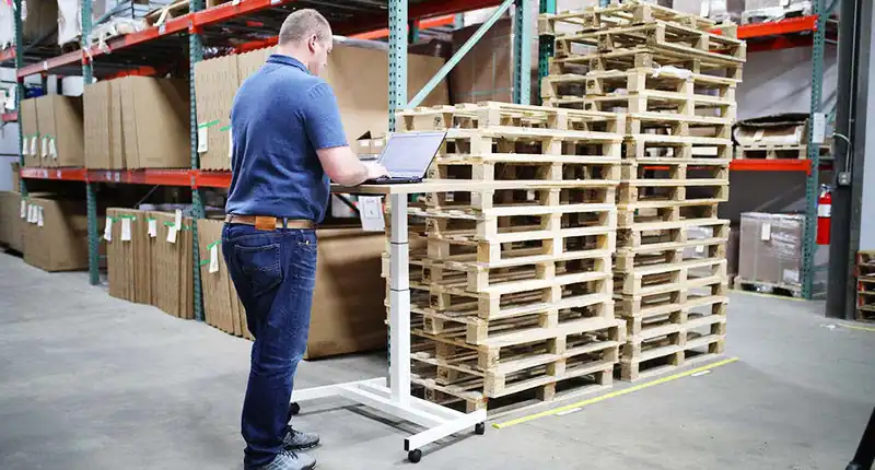 Software gestionale per aziende della distribuzione: magazzino con pallet e operatore al lavoro